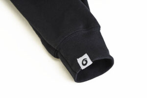 A close up of the sleeve on a black sweatshirt